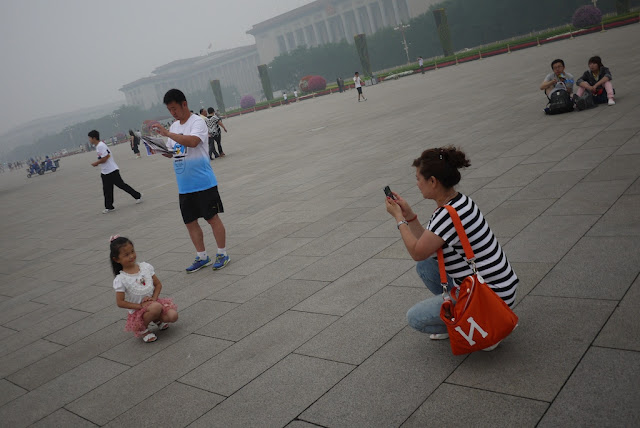 woman taking a photograph of her daughter at Tiananmen Square