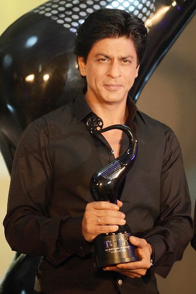 Shah Rukh Khan flashes his famous dimples while holding 'Times of India Film Awards' trophy during its unveiling, held in Mumbai on January 29, 2013.