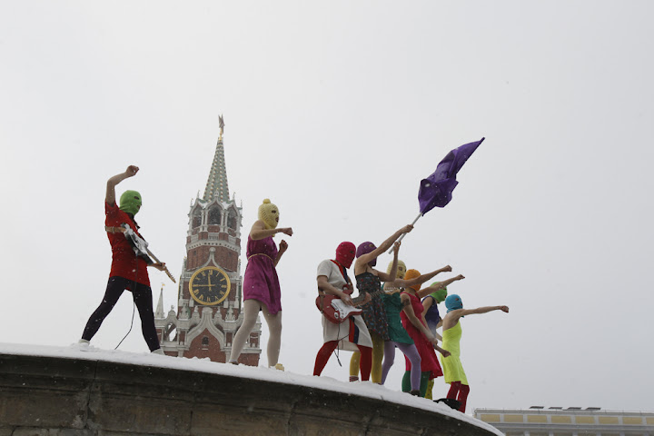 Image of Pussy Riot in concert in Red Square, five women in skirts and neon balaclavas in the snow