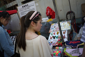 young woman look at items at a street market
