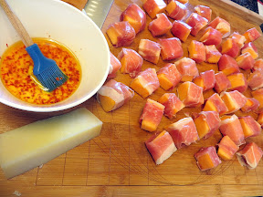 Prosciutto wrapped cantaloupe with red pepper lime oil and manchego recipe: preparing to brush on the spicy lime oil and top with manchego