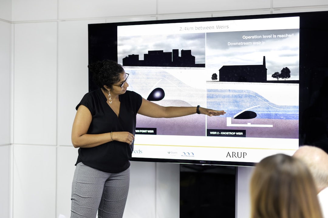A woman uses visual aids to deliver a presentation to her team members.