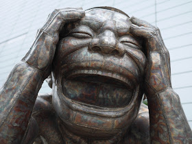 the laughing head of one of Yue Minjun's steel sculptures named "The Laugh that can be Laughed is not the Eternal Laugh"