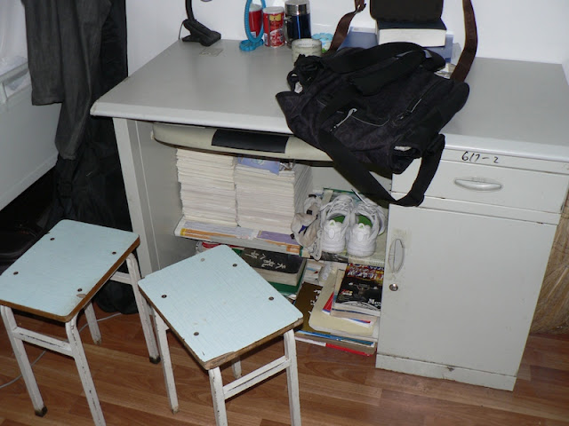 books stacked underneath a desk in a dorm room at Dalian Maritime University in China