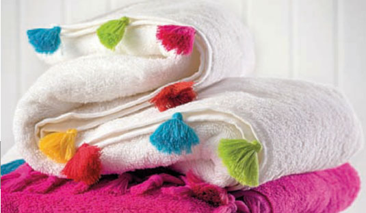 Sábanas y toallas decoradas con borlas.
