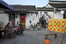 people playing cards outside of Chinese traditional style homes in Shaoxing, China