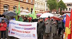 Demonstranten mit Regenschirmen und Transparent: »Faschismus ist keine Meinung sondern ein Verbrechen. Keine Toleranz für Nazis!«