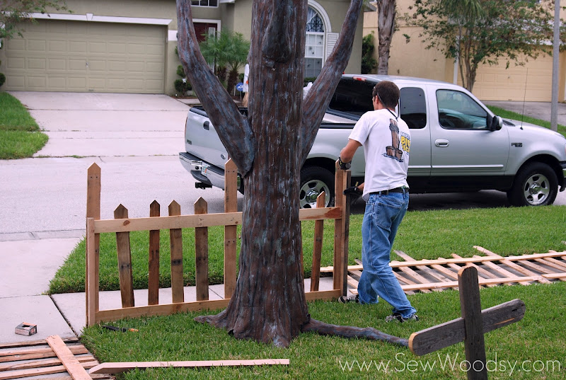 Man installing fence in the front yard.