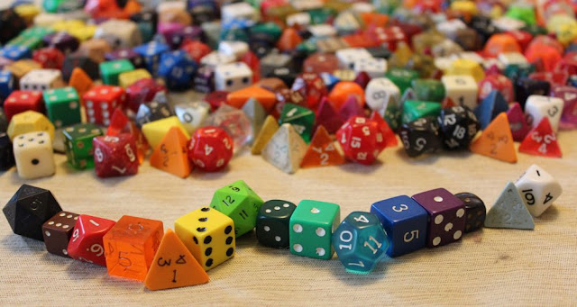 a sea of gaming dice, with a rainbow of dice in the foreground