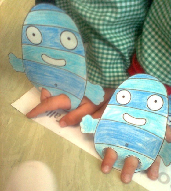 Niños jugando con marionetas de papel para dedos.