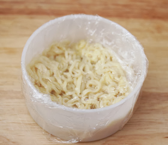 photo of ramen noodles pressed into a container and covered with cling wrap