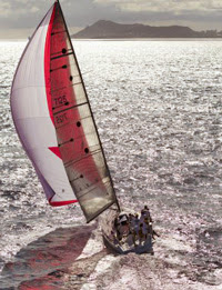 J/125 sailing under spinnaker to Transpac finish line off Hawaii