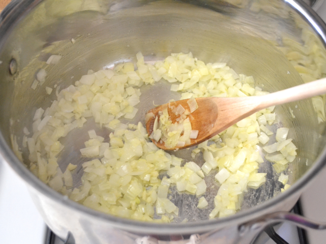 softened and cooked onions and garlic in pot with wooden spoon 