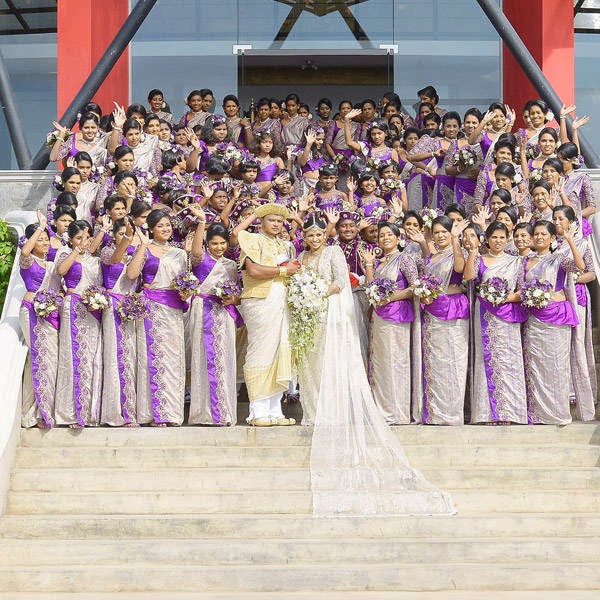 Sri Lankan wedding couple Nisansala (R) and Nalin (L) pose for photographers alongside their bridesmaids during their Guinness World Record-breaking wedding in Negombo, some 30kms north of Colombo, on November 8, 2013. Including 126 bridesmaids, 25 best men, 20 page boys and 23 flower girls the wedding breaks the previous record, held by a wedding in Bangkok that included 96 bridesmaids