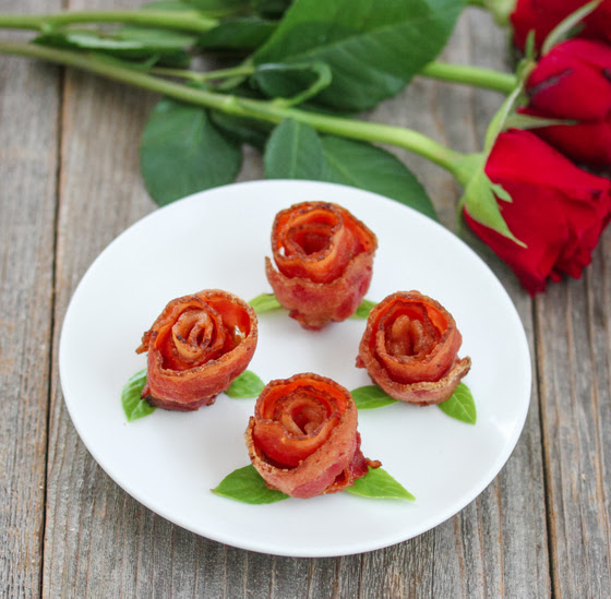 four bacon roses on a white plate