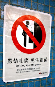 "No spitting" sign in Hong Kong with text "Spitting spreads germs"
