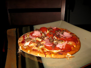 A pizza made with a pita crust on a plate. 
