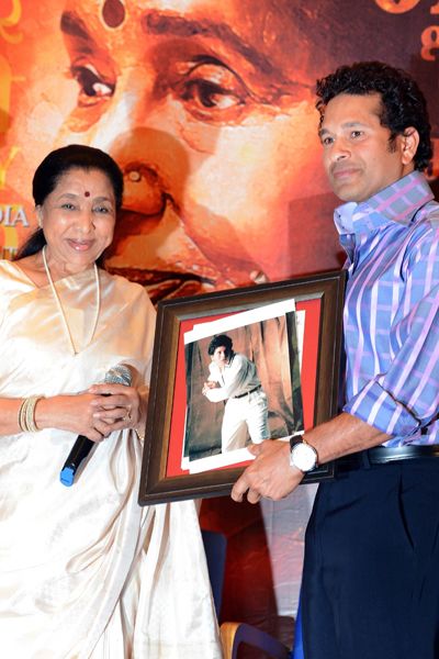 Asha Bhosle presents Sachin Tendulkar with his childhood photographs during the music launch of her debut movie 'Mai', held at Grand Hyatt in Mumbai. 