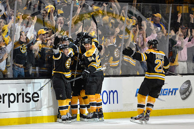 Bruins players celebrate Brad Marchand's overtime winning goal