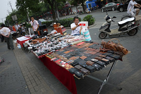 wallets and belts for sale on a sidewalk in Dachang Town, Shanghai