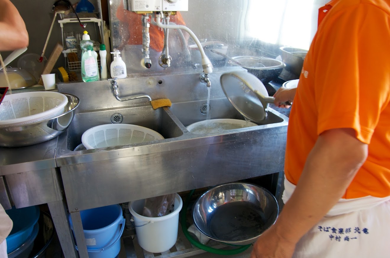 麺をすくって水に浸し、ぬめりを取るように冷たい水で洗います