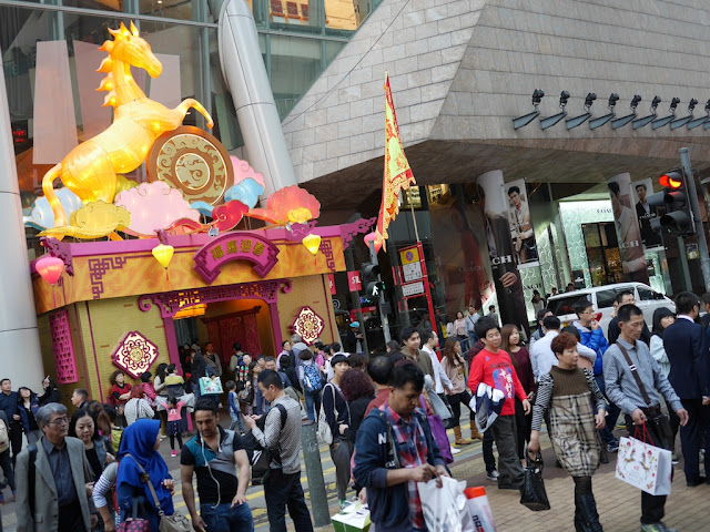many people around the open Lunar-New-Year-decorated entrance of Langham Place in Hong Kong