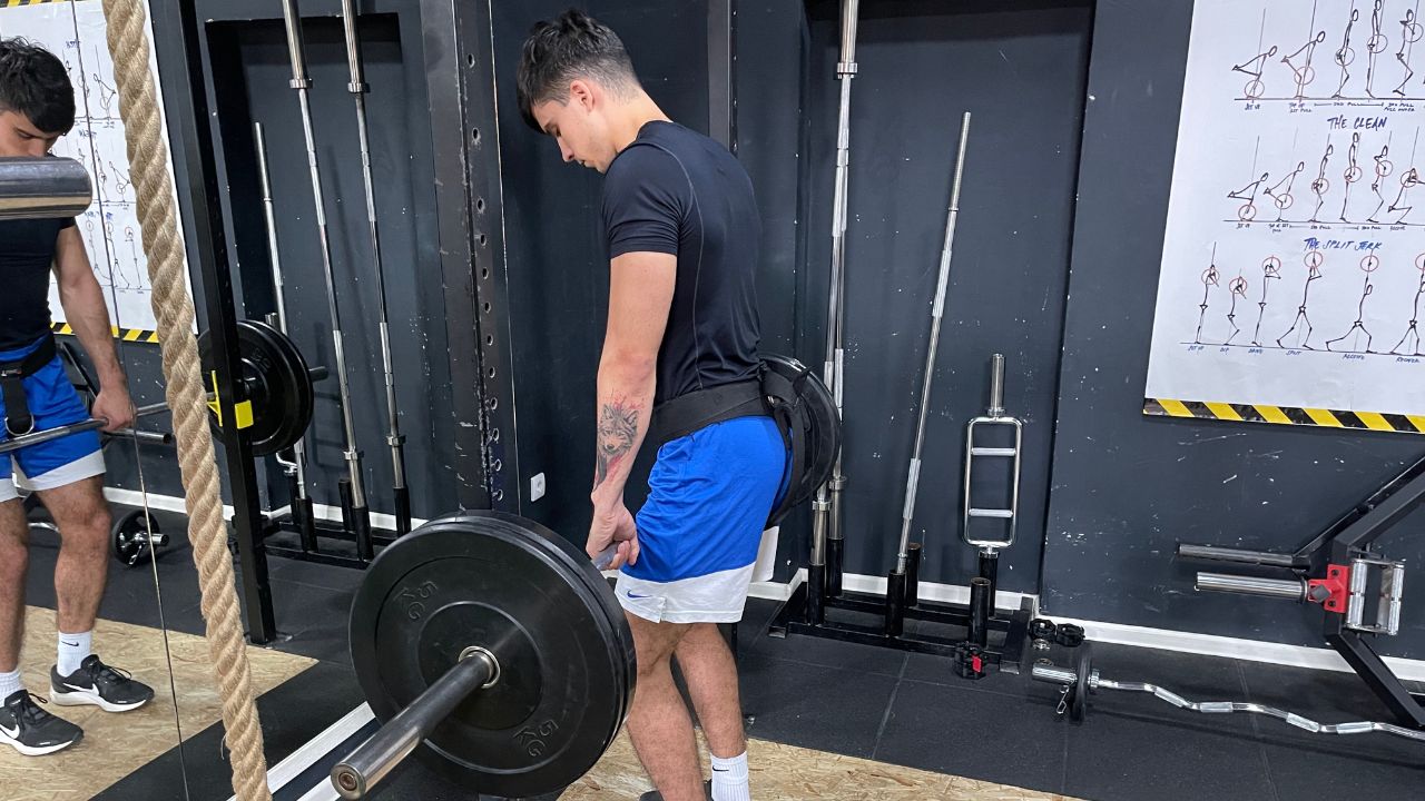 Vanja performs a rack pull exercise for the lower back in the commercial gym setup.