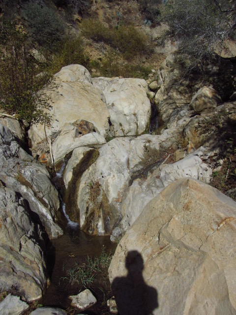 a shadow over a few rounded boulders with flow