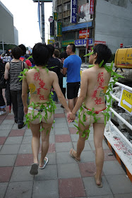 two young women holding hands with Chinese writing on their backs