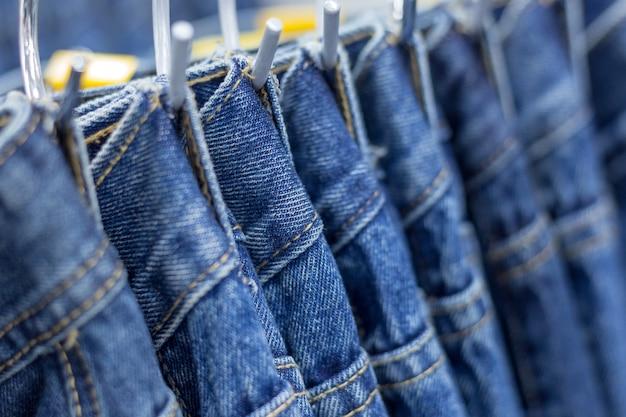 Premium Photo | Many denim jeans hanging on a rack
