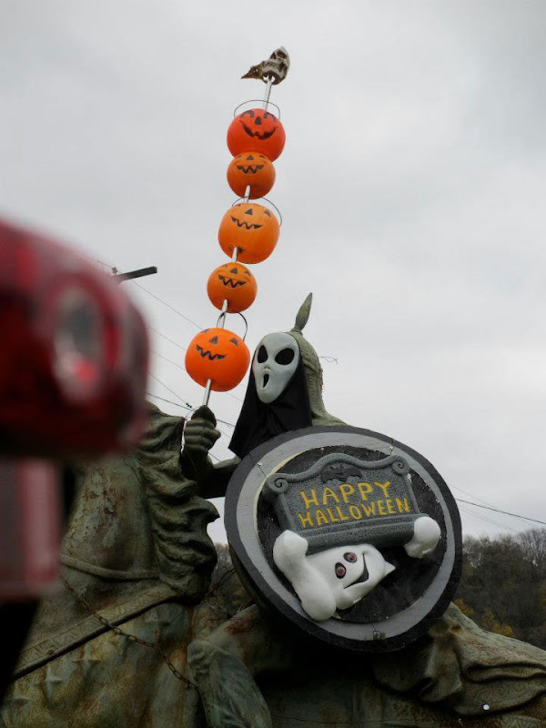 Wearing scream mask. 5 pumpkins skewered on his sword.