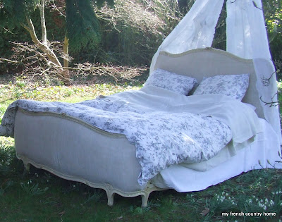 daybed in the garden with curtains hung above