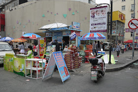 promotion for bottled drinks and other items for sale at a street corner