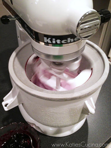 White KitchenAid Stand Mixer with ice cream attachment churning blue ice cream.