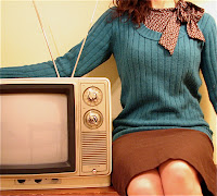 Girl seated next to retro TV