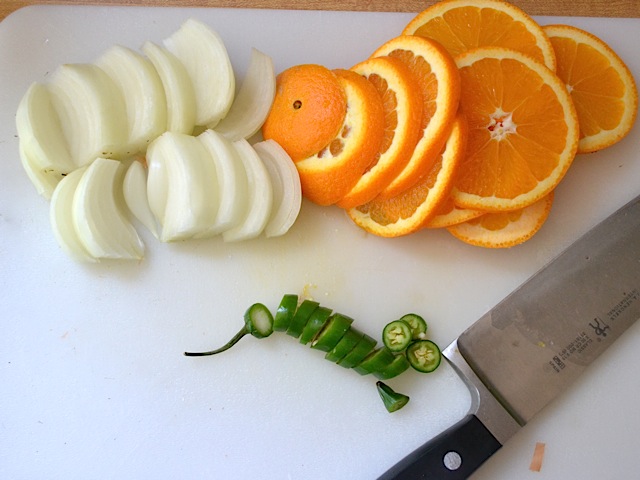orange, onion and serrano pepper sliced up with knife 