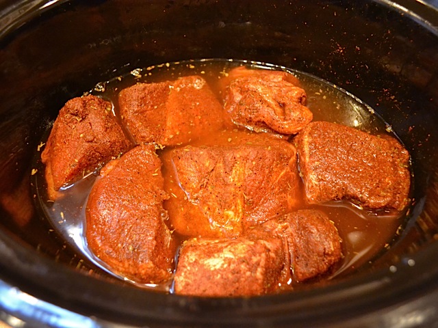 seasoned meat placed in slow cooker with just enough water to cover them 