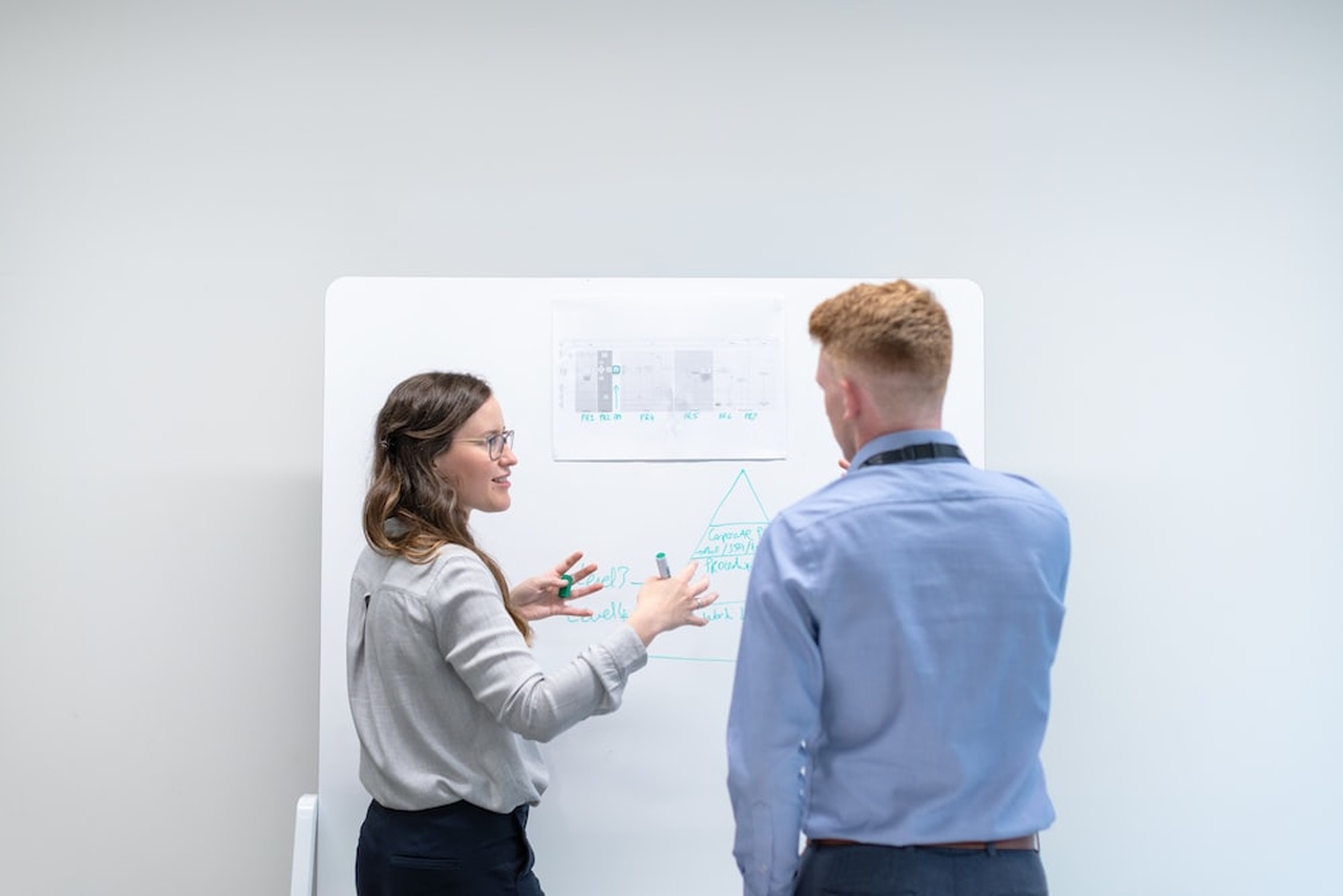 people discussing with facts and rates on a whiteboard