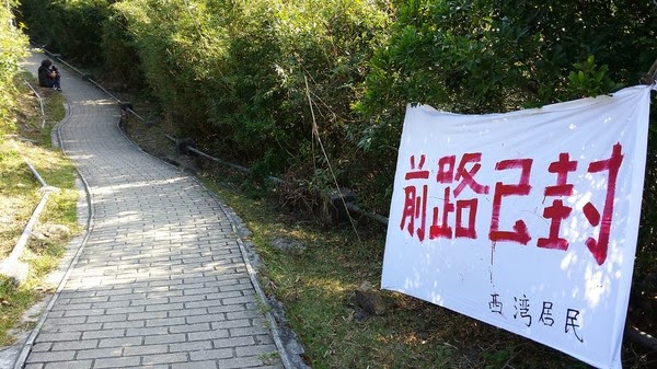 圖:2013 年毅行者比賽期間,大浪西灣村民封閉必經之路,迫使大會臨時改道。Credit: Thomas Fan