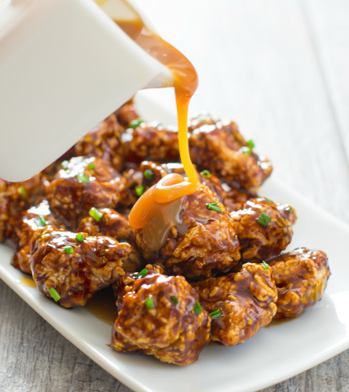pouring sauce over the soy caramel chicken bites