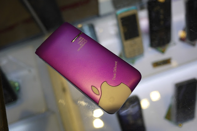 purple phone in China with a partial Apple logo and phrases Think Different and I SEE THINGS A LITTLE DIFFERENTLY