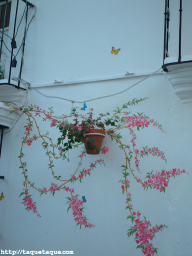 flores y mariposas pintadas en la fachada de la terraza del MaduBar Fusion, en Estepona (Málaga)