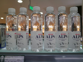 bottles of water with the name "Alps" in English and "阿尔卑斯" in Chinese