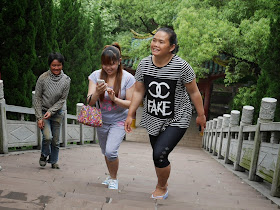 woman in China wearing a shirt with an imitation of Chanel's logo and the word 'FAKE'