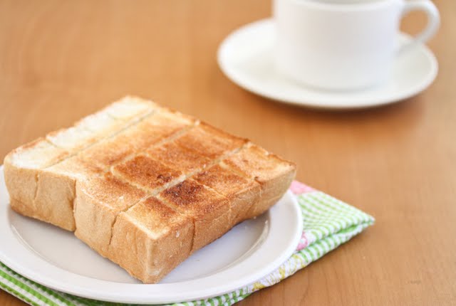 plain brick toast with a white coffee cup in the background