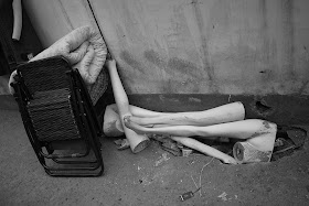 folded chairs, blankets, and broken mannequin legs on a street in Changsha, China