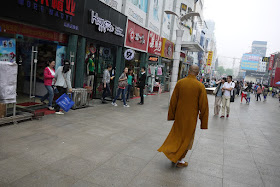 monk walking on a pedestrian street