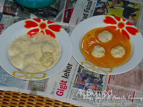 Nugget ikan dicelup dalam telur sebelum ditabur serbuk roti