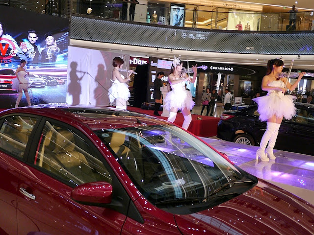 four women in white dresses playing electric clear violins