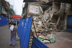 woman carrying bags next to a demolished building at Beizheng Street in Changsha, China